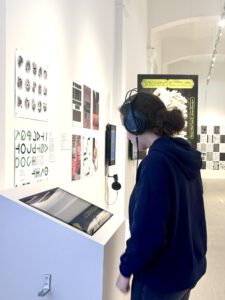 Person, die Infovideos zur Ausstellung anschaut