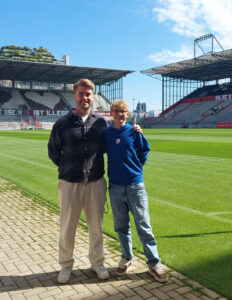 Erinnerungsfoto mit dem Betreuer und Henri F. Foto von Henri F. und seinem Betreuer neben dem Rasen des millerntor-stadions